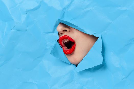 woman's face breaks through blue mockup close-up. High quality photo