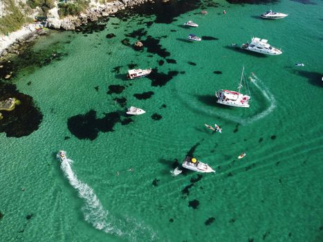 Sea landscape with rocky coastline on sunset time with cloudy sky. Yachts in the Sea on a background of rocky shores. The concept of perfect place for summer travel and rest.