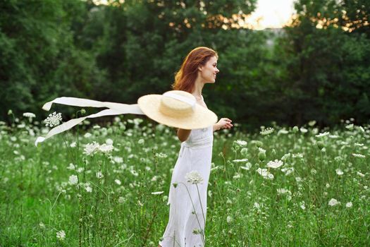 Woman in white dress hat holding flowers nature walk. High quality photo