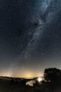 Milky way, roads, bridges, dams and car lights, vertical composition