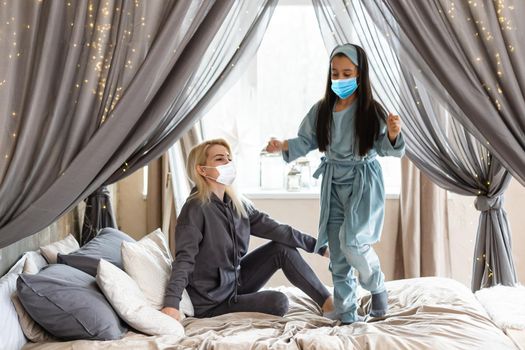 Mother and daughter in medical face mask Christmas concept.