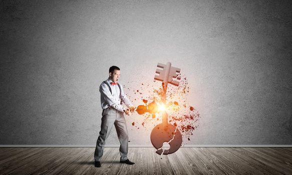 Determined businessman in empty interior breaking with violin stone key figure