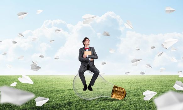 young businessman with a book. flying around paper plane in chaos