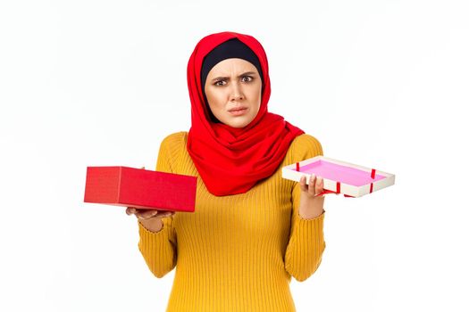 cheerful muslim woman shopping holiday gifts light background. High quality photo