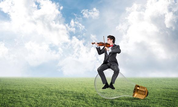 young businessman plays the violin, the concept of creativity in business