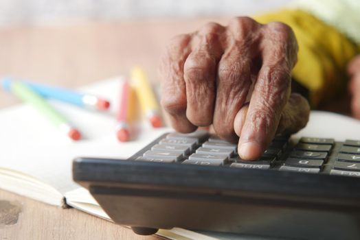 senior women hand using calculator on desk .