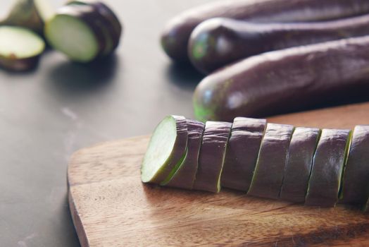 cutting eggplant on a chopping board .