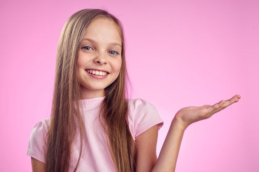 cute girl with long hair on pink background lifestyle childhood. High quality photo