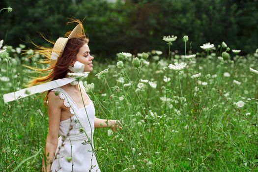 Woman in white dress and hat in a field with flowers lifestyle. High quality photo