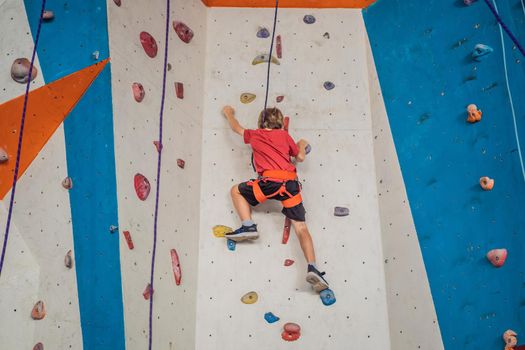 Boy at the climbing wall without a helmet, danger at the climbing wall.