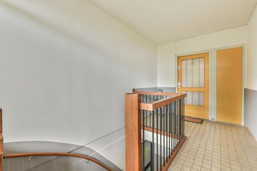 Corridor with wooden staircase and glass railings