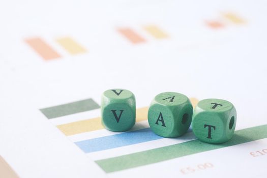 Wooden block with a VAT word on financial data .