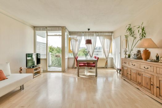 Huge room with a full wall window and lots of furniture