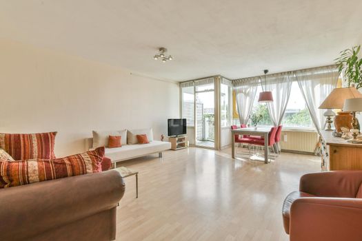 Huge room with a full wall window and lots of furniture