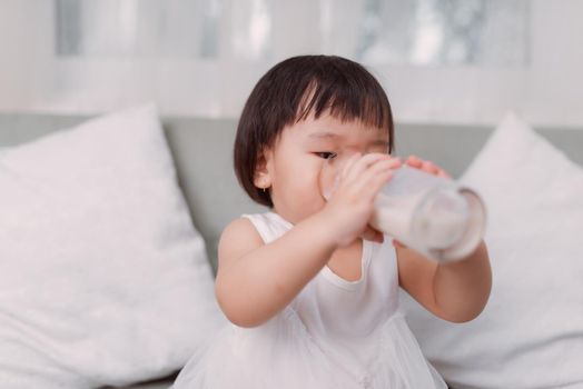 Little asian girl drinking milk