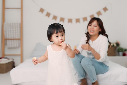 Mother and daughter playing together in bedroom