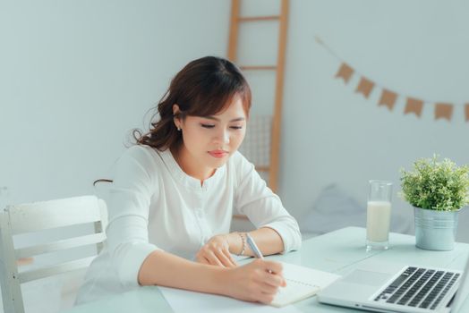 Asian young woman use laptop to work at home