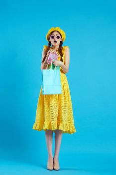 smiling woman in a yellow hat Shopaholic fashion style blue background. High quality photo