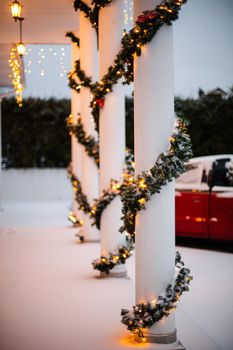 Christmas porch.Snowy courtyard with Christmas porch, veranda, wreath, Christmas tree, garland,christmas balls and lanterns.