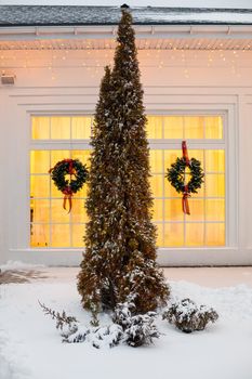 House decorated for Christmas with red car.