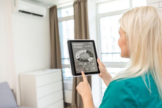 Woman at home using smart screen, automation domestic system.