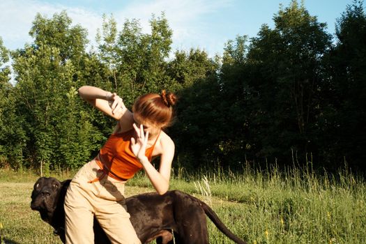woman outdoors in the field with dog friendship playing. High quality photo