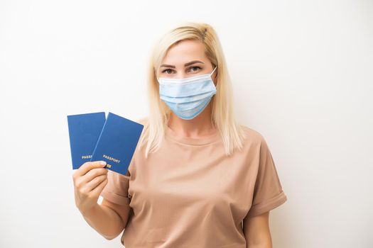Covid-19 Health Passport. masked woman holding passports.