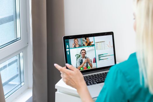 Businesswoman making video call to business partner using laptop. Close-up rear view of young woman having discussion with corporate client. Remote job interview, consultation, human resources concept.