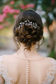 Bridal hairstyle with hairpin and curls. Close-up. Back view. High quality photo