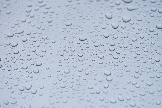 Condensation drops on a gray background, close-up. Liquid condensation on a flat surface, evaporation
