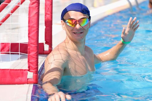 The goalkeeper plays water polo in the pool, close-up. Sports competitions on the water, summer outdoor pool