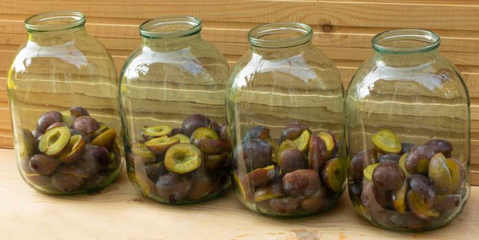 Plums placed in jars - Plum compote in the cooking process.