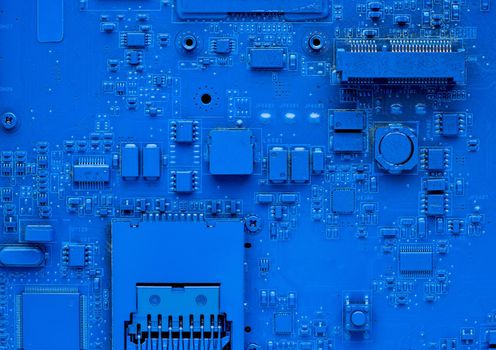 Computer motherboard. Classic blue background with pc backdrop, close up. Single color microchip, top view