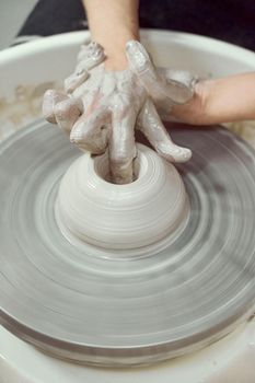 Woman making ceramic pottery on wheel, hands closeup. Concept for woman in freelance, business, creative hobby. Earn extra money, side hustle, vertical