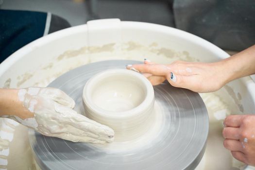 Women making ceramic pottery, concept for a workshop and master class, four hands close-up, focus on potters, palms with pottery. Two woman. Creative hobby concept. Earn extra money, side hustle