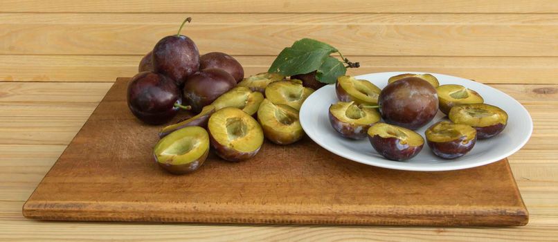 Fresh juicy plums on a wooden background.