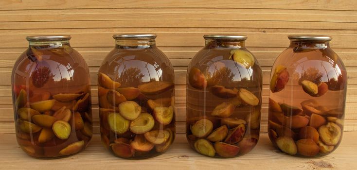 Fresh plum compote on wooden background freshly cooked.