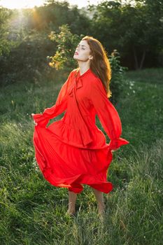 attractive woman in red dress outdoors in freedom field. High quality photo