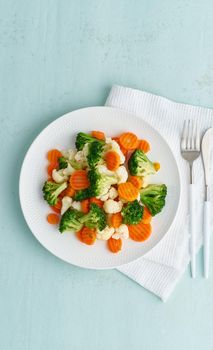 Mix of boiled vegetables. Broccoli, carrots, cauliflower. Steamed vegetables for dietary low-calorie diet. FODMAP, dash diet, vegan, vegetarian, vertical, top view, copy space