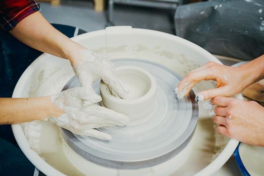 Women making ceramic pottery, concept for a workshop and master class, four hands close-up, focus on potters, palms with pottery. Two woman. Creative hobby concept. Earn extra money, side hustle