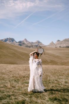 Girl with a tambourine in her hands stands in a field. High quality photo