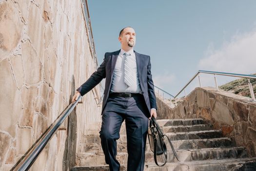 Business executive with briefcase going down the stairs.