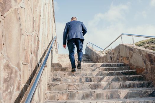 Business executive with briefcase going down the stairs.