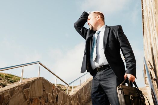 Business executive with briefcase going down the stairs.