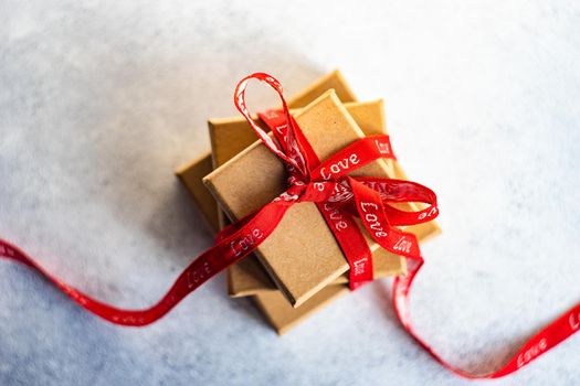Holiday card concept with gift boxes and ribbon on concrete background