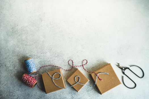 Holiday card concept with gift boxes and ribbon on concrete background