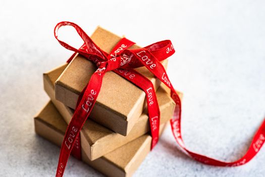 Holiday card concept with gift boxes and ribbon on concrete background