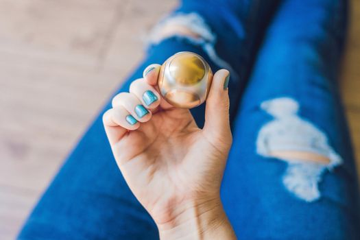 Girl teenager in holey jeans holds in hands and plays with spinner.