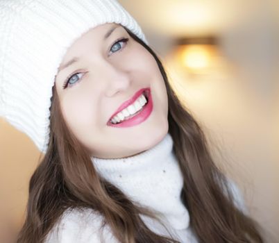 Christmas, people and winter holiday concept. Happy smiling woman wearing white knitted hat as closeup face xmas portrait.