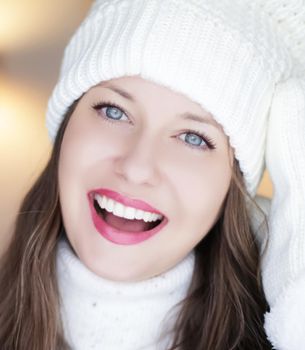 Christmas, people and winter holiday concept. Happy smiling woman wearing white knitted hat as closeup face xmas portrait.